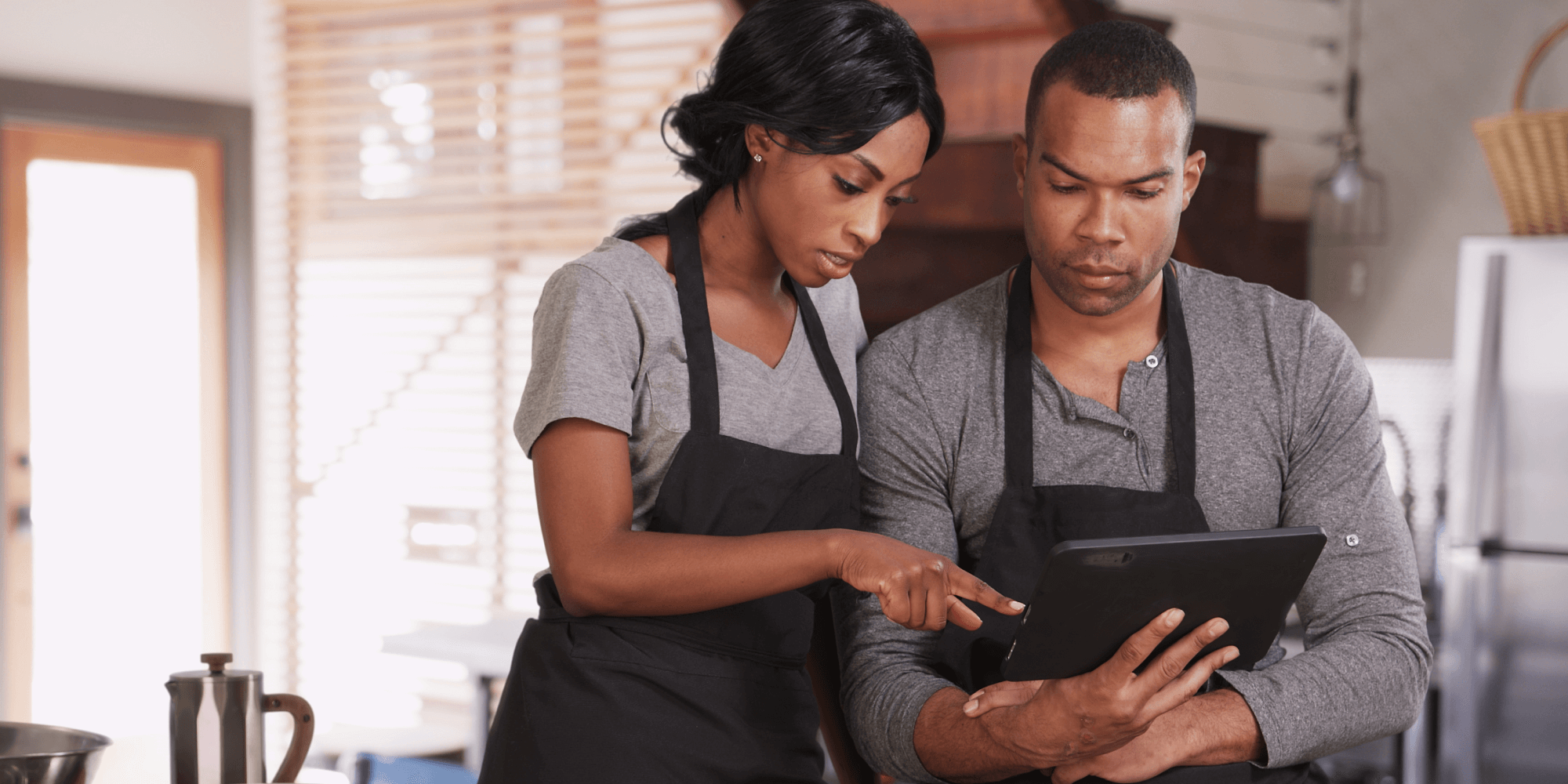 business owners standing over tablet searching insurance revolution for a business insurance quote